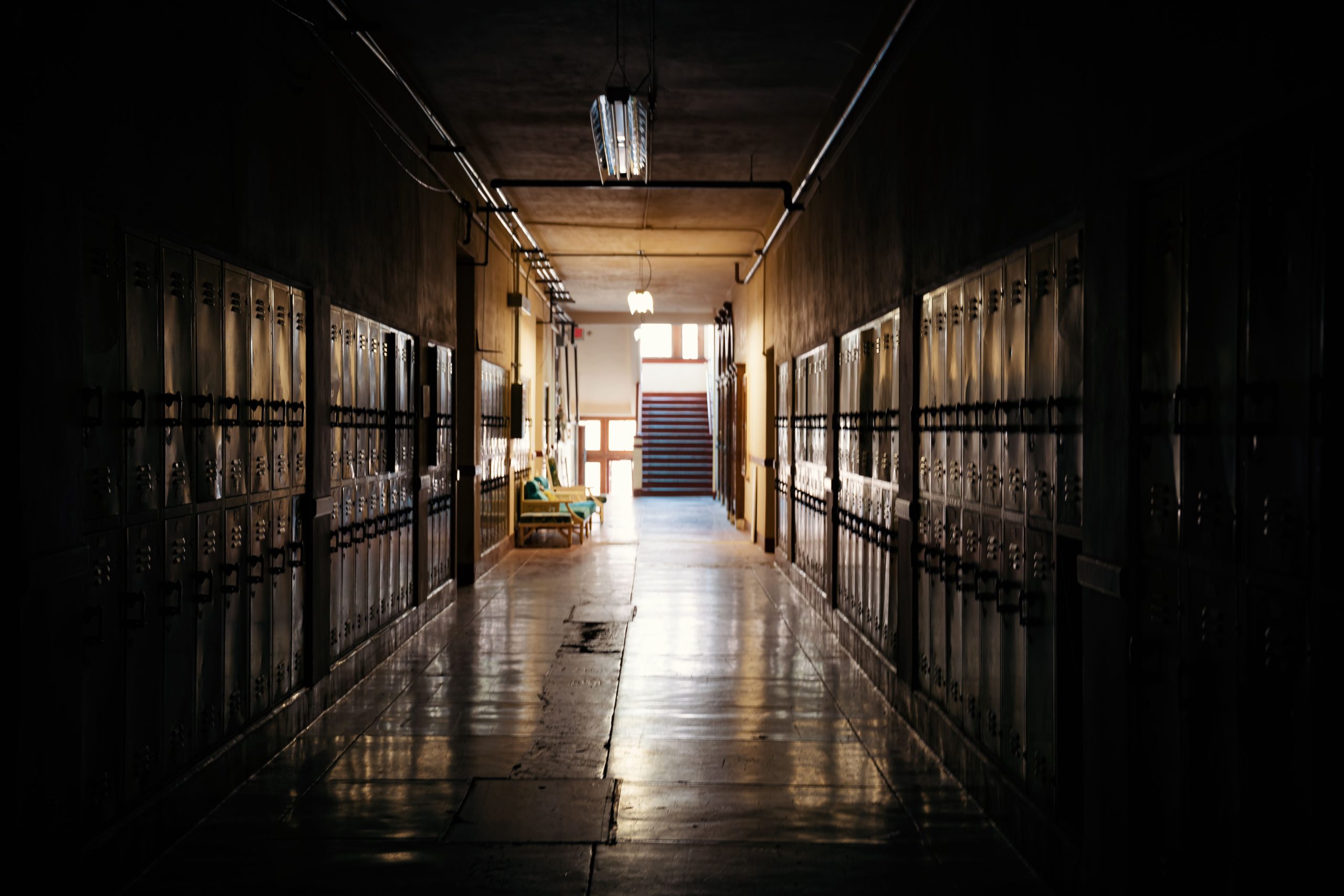 Couloir d'école sombre avec casiers et lumière au fond