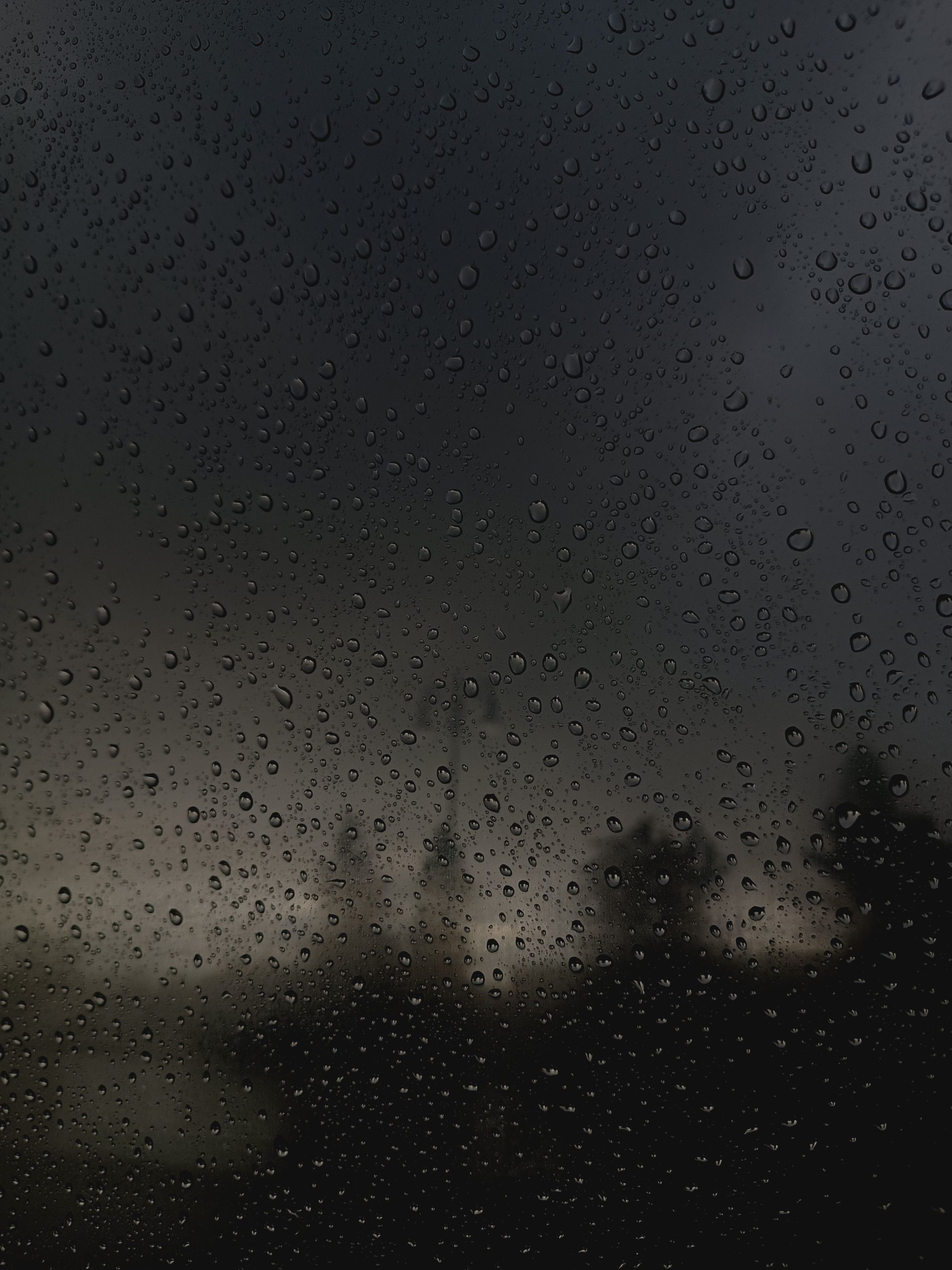 Gouttes de pluie sur une vitre sombre la nuit