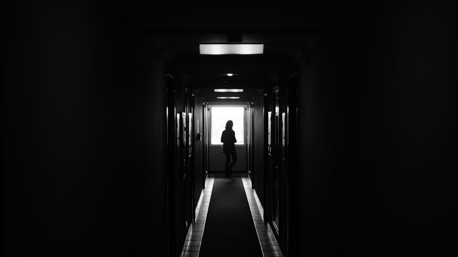 Silhouette dans un couloir sombre, évocation des rêves d'angoisse et de peur — La Clé des Songes